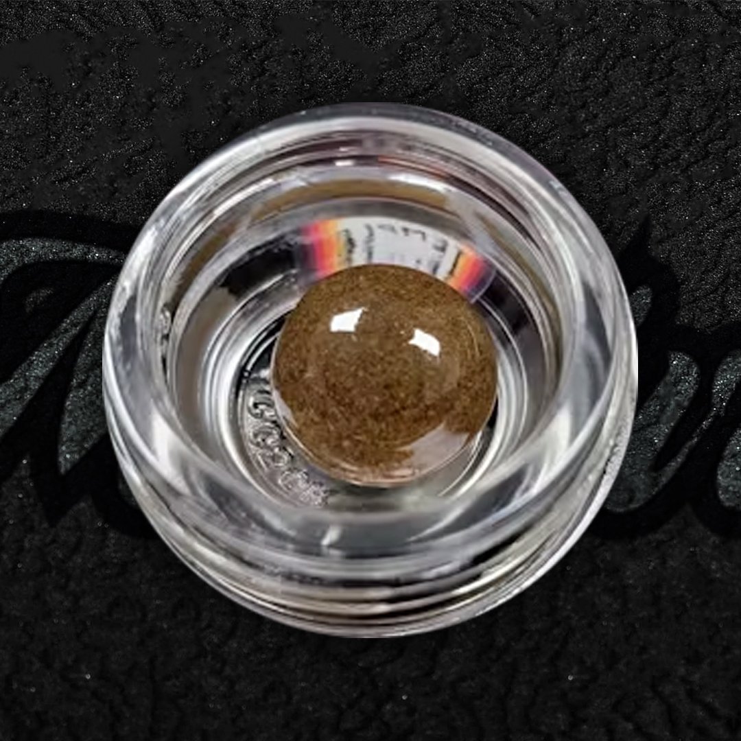 Nepalese Temple Ball Hash shown with glossy black surface and sticky golden-brown interior. Traditional handcrafted hash with smooth texture and calming effects.